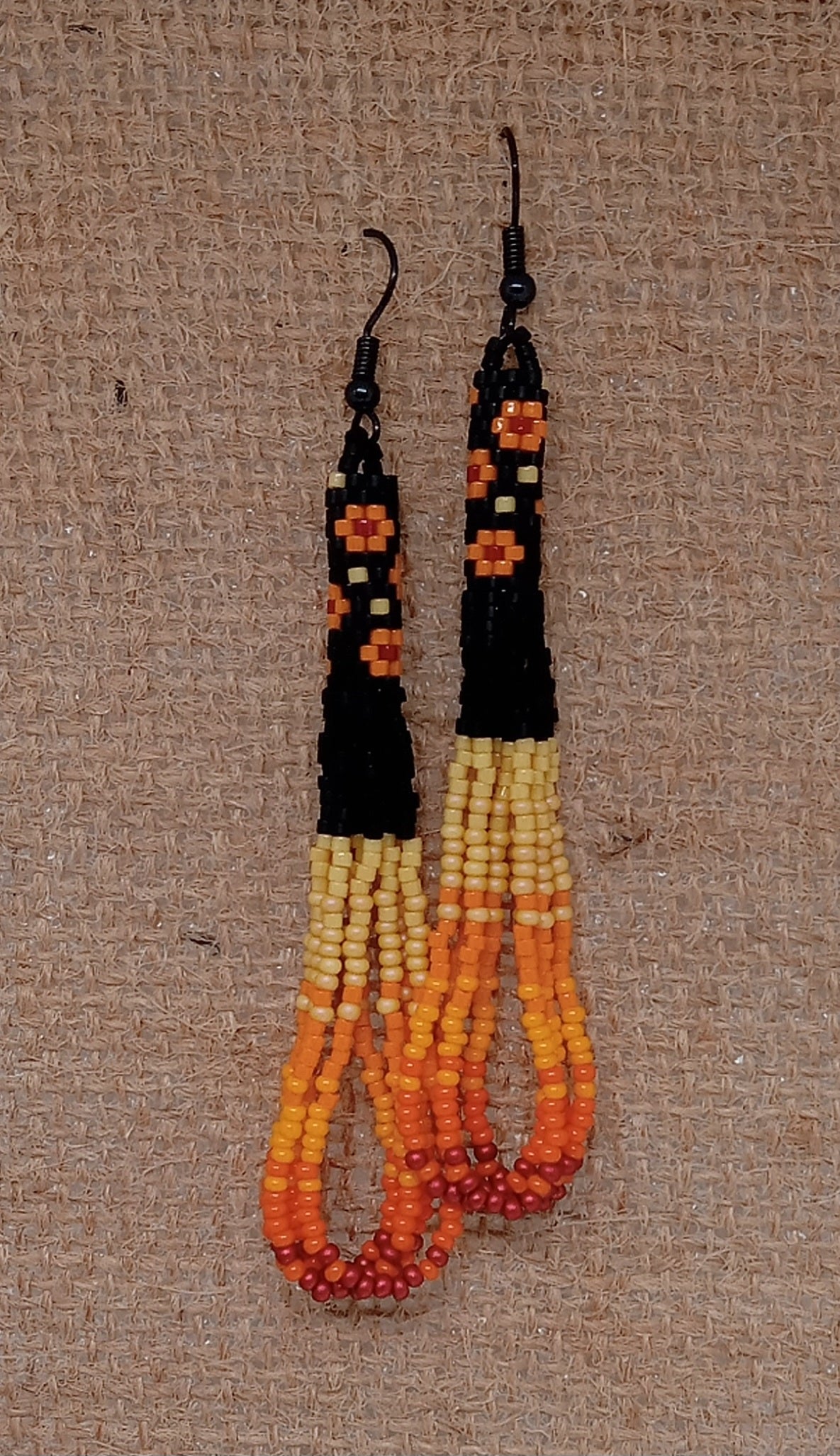 Orange and black floral loop fringe earrings.