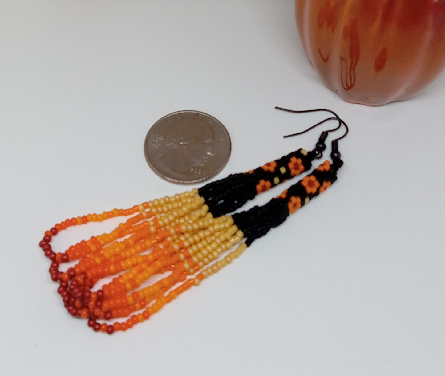 Orange and black floral loop fringe earrings.